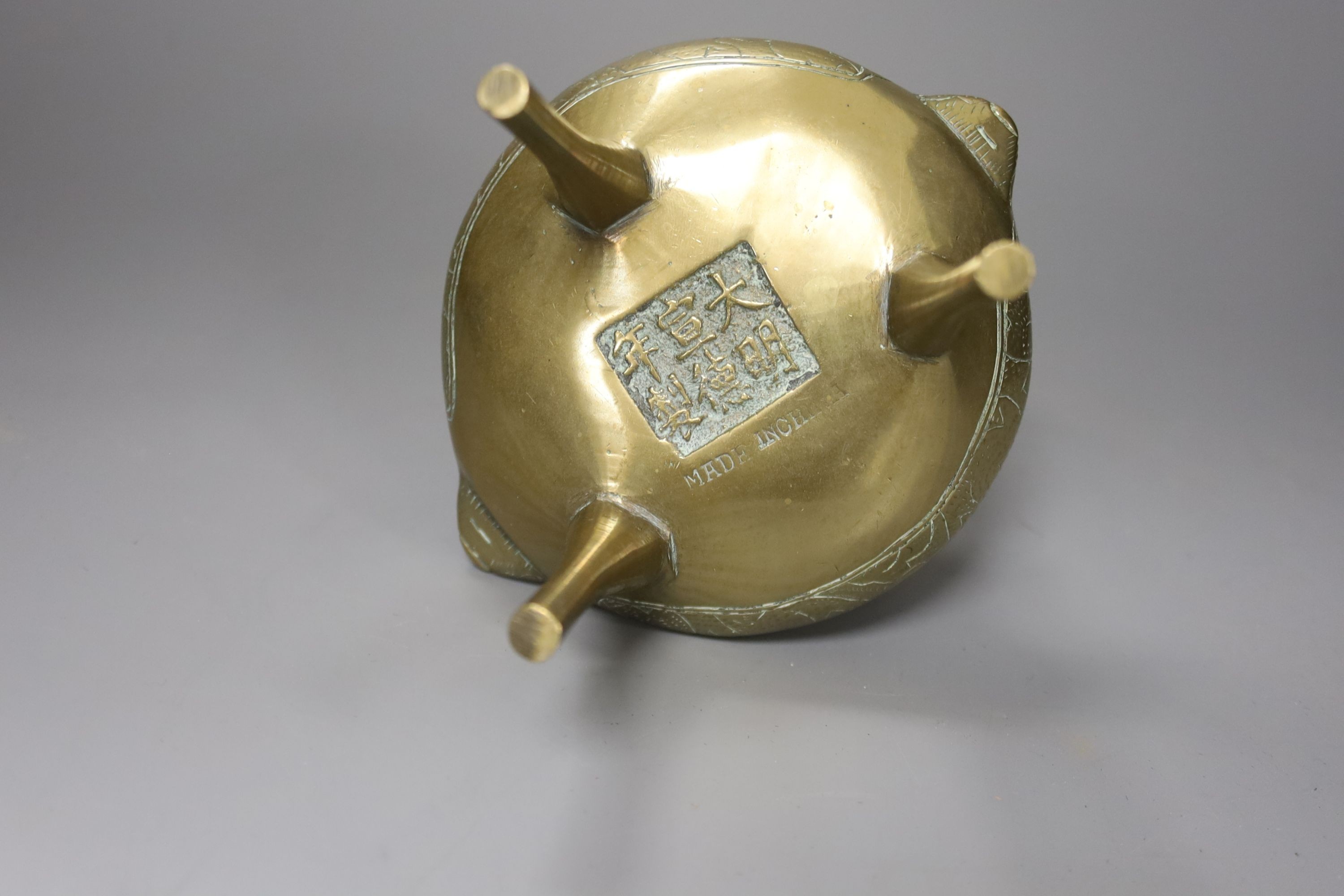 A Chinese brass tripod censer and cover, Xuande mark, 12 cms high.